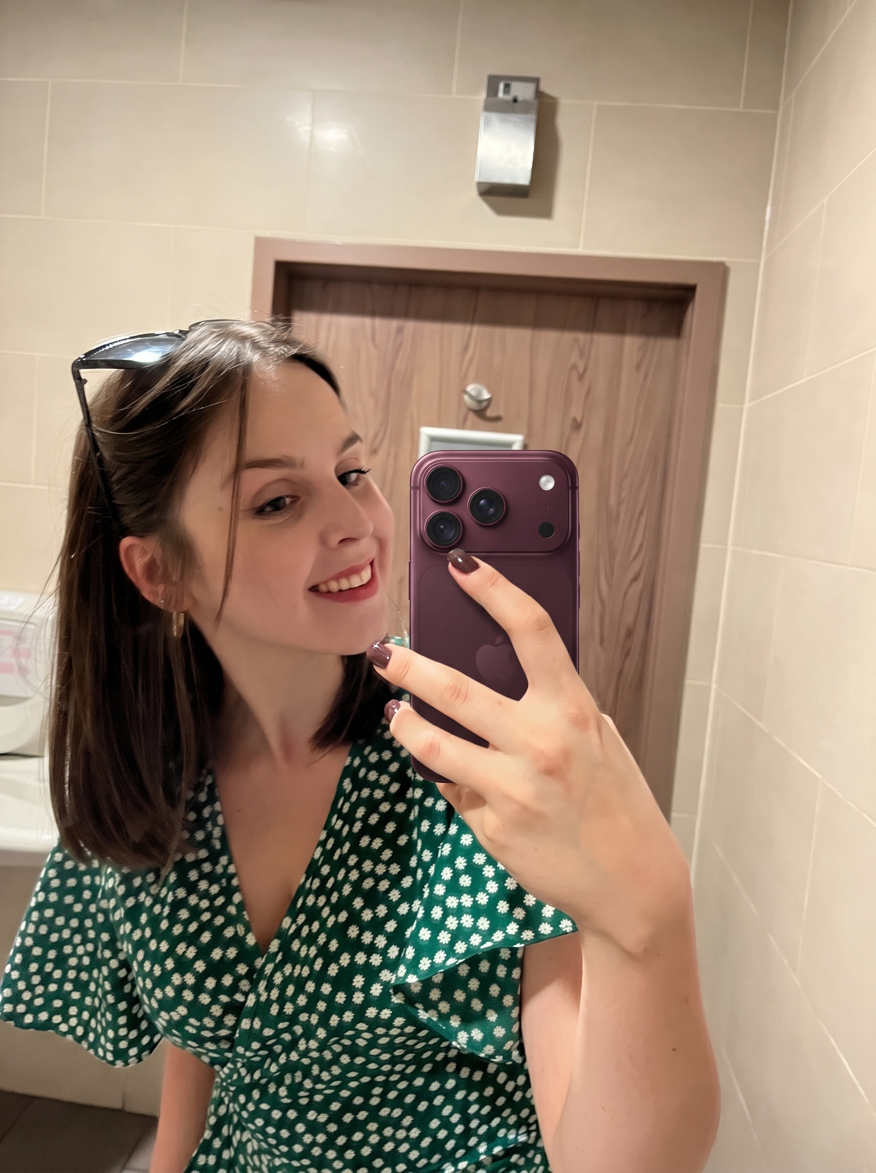 Sylwia filming content on her phone in sunglasses and a white shirt