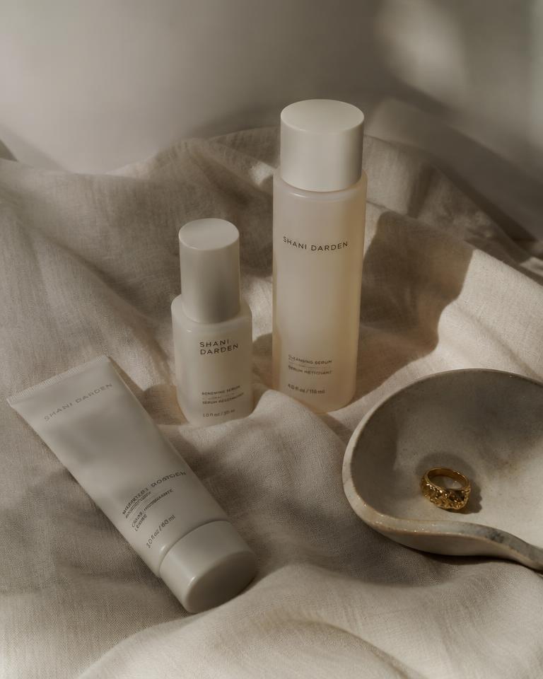 Minimal skincare bottles arranged on cream linen